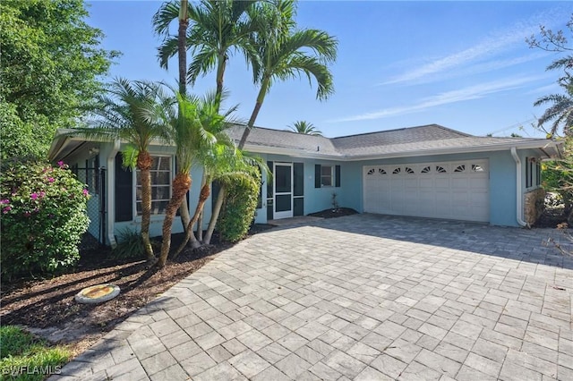 single story home with stucco siding, driveway, and a garage