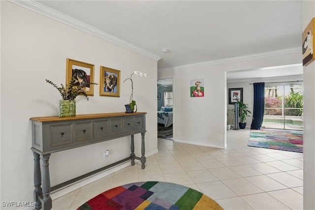hallway featuring crown molding, baseboards, and light tile patterned floors