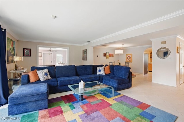 living room with light tile patterned floors, arched walkways, and ornamental molding