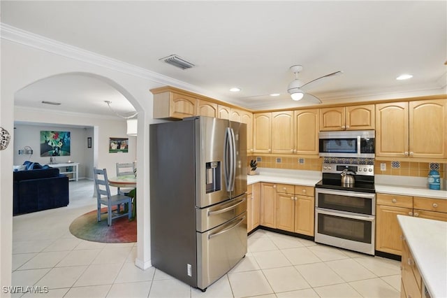 kitchen with crown molding, light brown cabinetry, appliances with stainless steel finishes, light countertops, and arched walkways