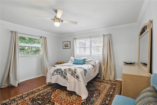 bedroom with baseboards, multiple windows, ornamental molding, and wood finished floors