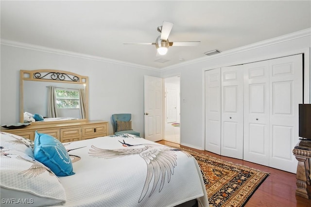 bedroom with a ceiling fan, visible vents, crown molding, wood finished floors, and a closet