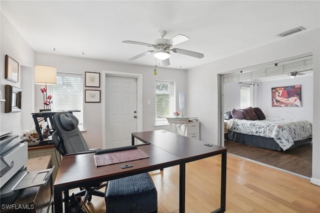 home office featuring a ceiling fan, light wood-style flooring, and visible vents