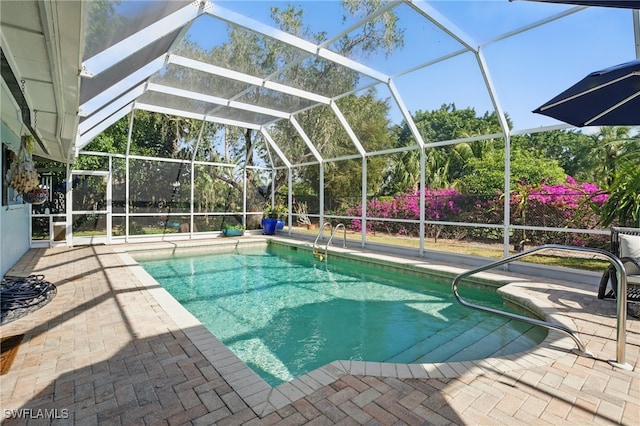 outdoor pool featuring a patio and glass enclosure