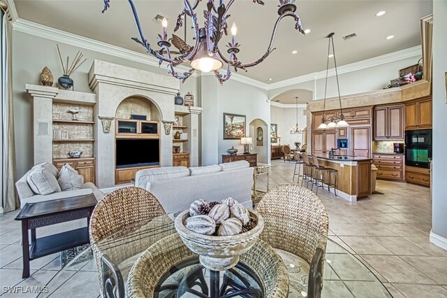 dining space featuring ornamental molding, sink, light tile patterned floors, and an inviting chandelier