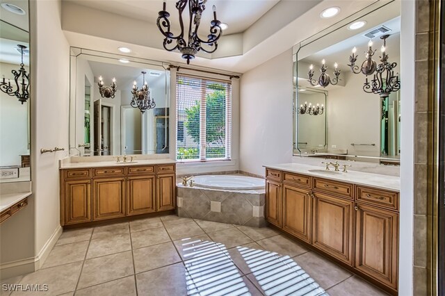 bathroom featuring tiled tub, tile patterned flooring, and vanity