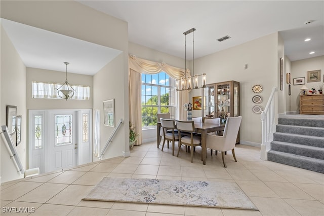 dining room with light tile patterned flooring and a towering ceiling