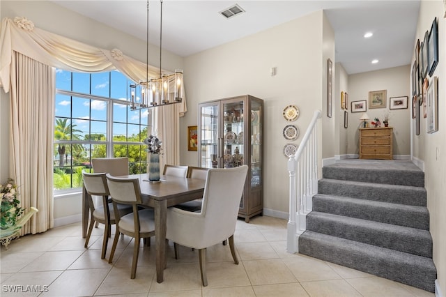 dining space with light tile patterned floors and an inviting chandelier