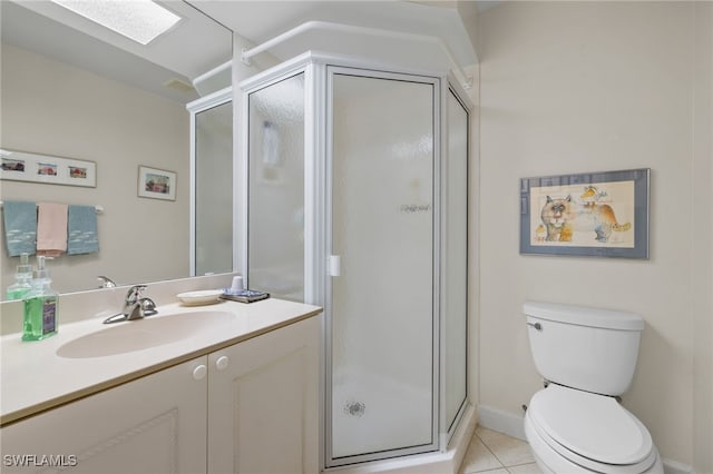 bathroom with a skylight, an enclosed shower, vanity, tile patterned flooring, and toilet