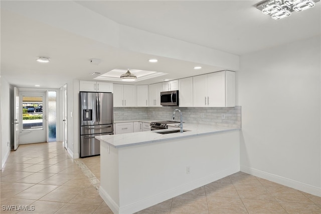 kitchen featuring kitchen peninsula, stainless steel appliances, sink, light tile patterned floors, and white cabinetry