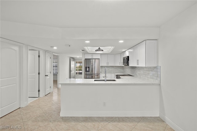 kitchen with sink, stainless steel appliances, backsplash, kitchen peninsula, and white cabinets