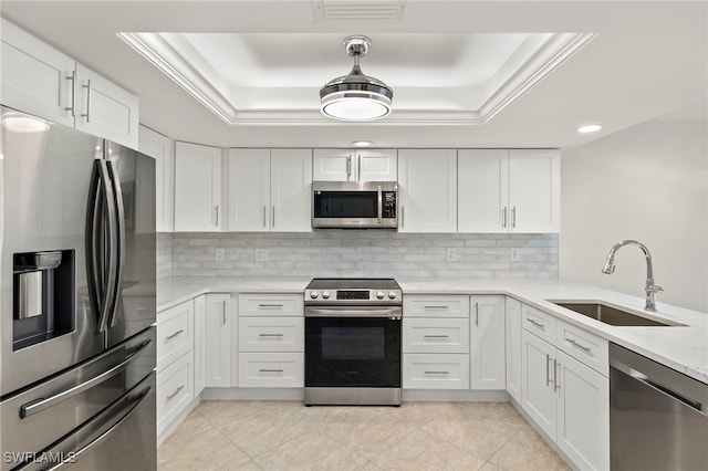 kitchen with white cabinets, stainless steel appliances, a raised ceiling, and sink