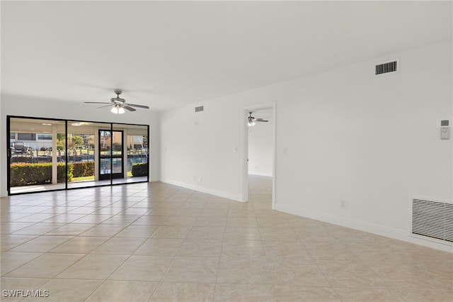 empty room with ceiling fan and light tile patterned flooring