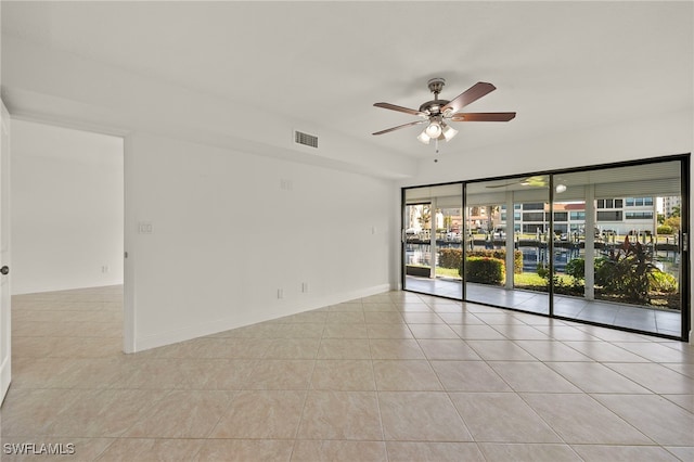 tiled empty room featuring ceiling fan