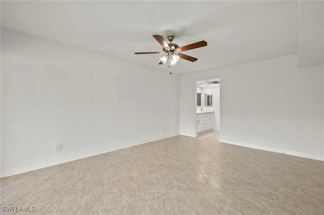 tiled empty room featuring ceiling fan