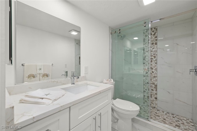 bathroom featuring vanity, toilet, and a shower with shower door