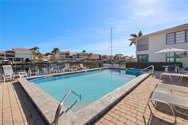 view of pool featuring a patio area and a water view