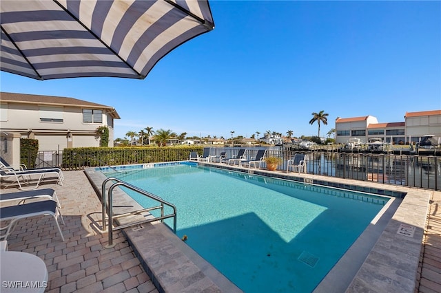 view of pool featuring a water view and a patio