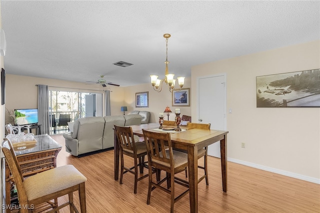 dining room featuring a textured ceiling, ceiling fan with notable chandelier, and light hardwood / wood-style floors