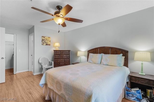 bedroom with a closet, ceiling fan, light hardwood / wood-style flooring, and a spacious closet