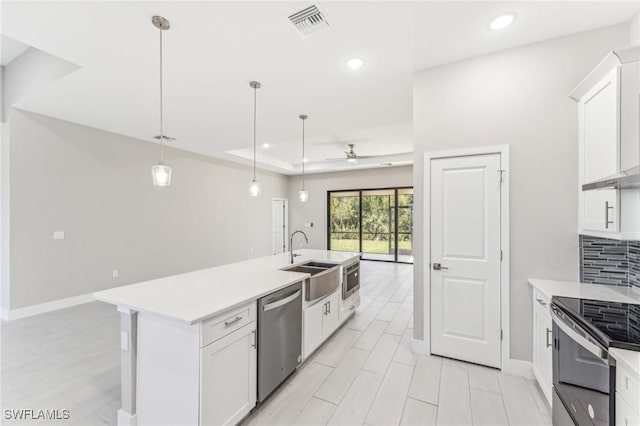 kitchen with ceiling fan, sink, decorative light fixtures, white cabinets, and appliances with stainless steel finishes