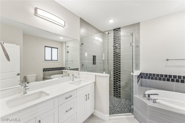 full bathroom featuring vanity, toilet, and independent shower and bath