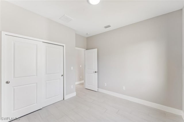 unfurnished bedroom featuring a closet and light wood-type flooring