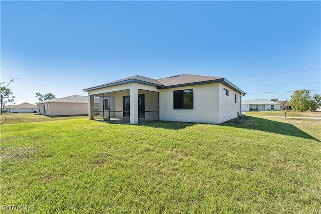 rear view of property with a lawn and a sunroom