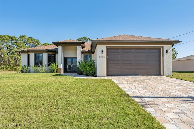 prairie-style house featuring a front yard, french doors, and a garage