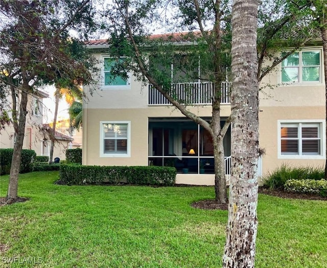 rear view of property featuring a lawn