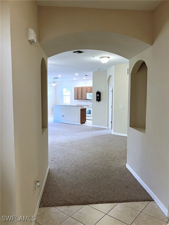 hall featuring light colored carpet