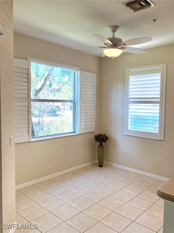 empty room featuring ceiling fan and light tile patterned floors