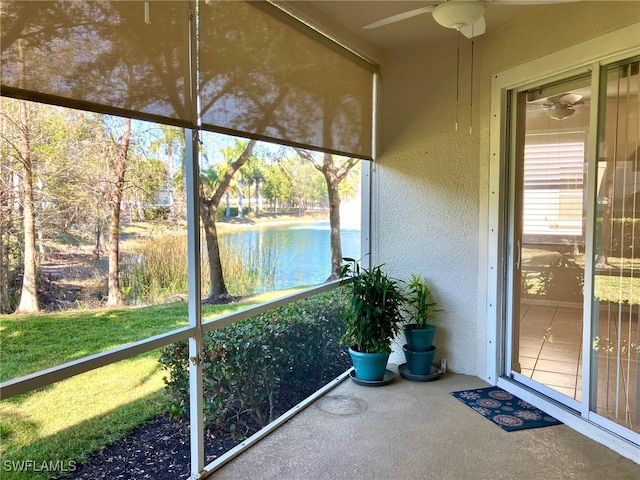 unfurnished sunroom with a water view and ceiling fan