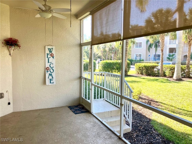 unfurnished sunroom with ceiling fan