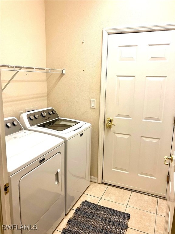 laundry area featuring washer and dryer and light tile patterned floors