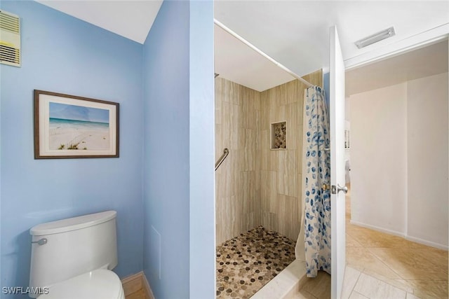 bathroom with curtained shower, tile patterned flooring, and toilet