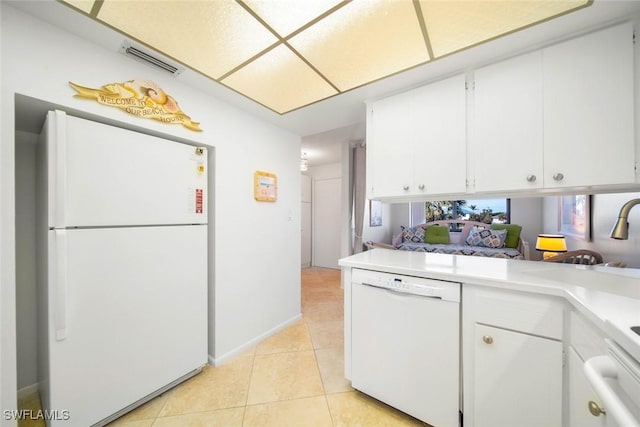 kitchen featuring white cabinetry, light tile patterned flooring, and white appliances