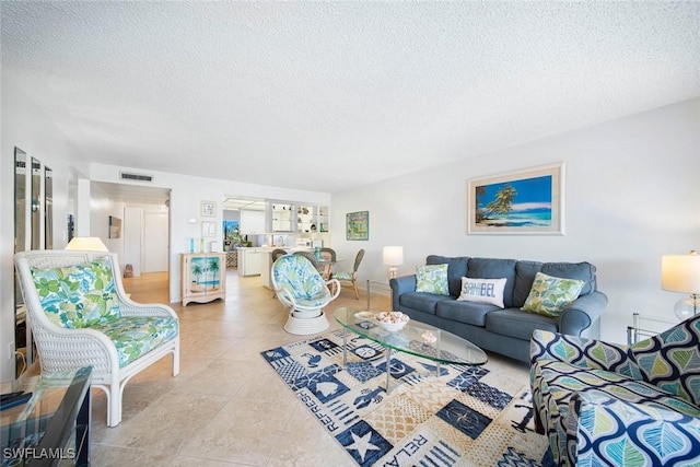 1440 Middle Gulf Dr Unit 2E, Sanibel, FL 33957 - tiled living room featuring a textured ceiling