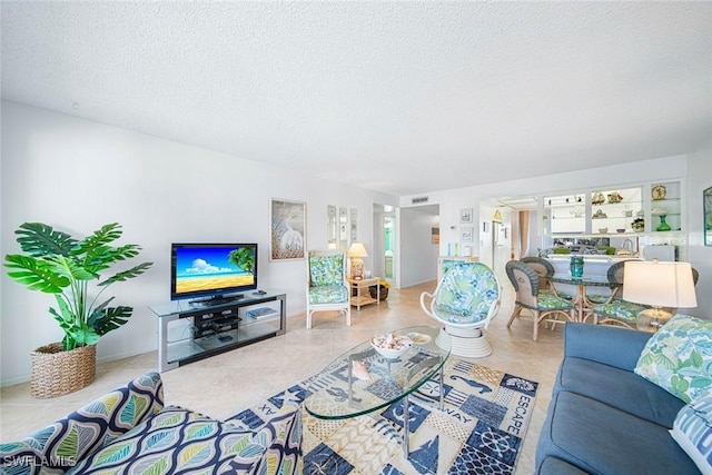 living room featuring light tile patterned flooring and a textured ceiling