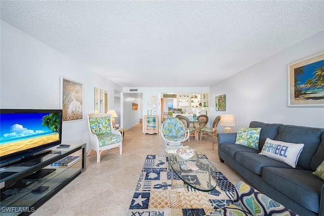 tiled living room featuring a textured ceiling