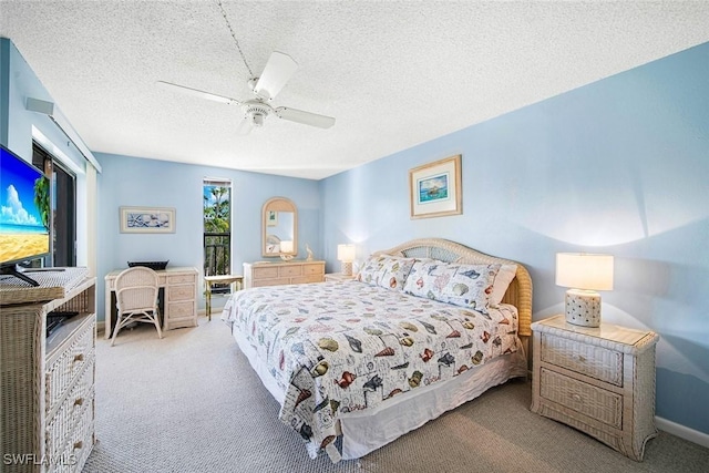 carpeted bedroom featuring ceiling fan and a textured ceiling