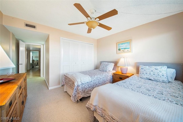 carpeted bedroom with ceiling fan and a closet