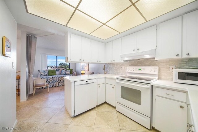 kitchen featuring kitchen peninsula, white cabinets, light tile patterned flooring, and white appliances