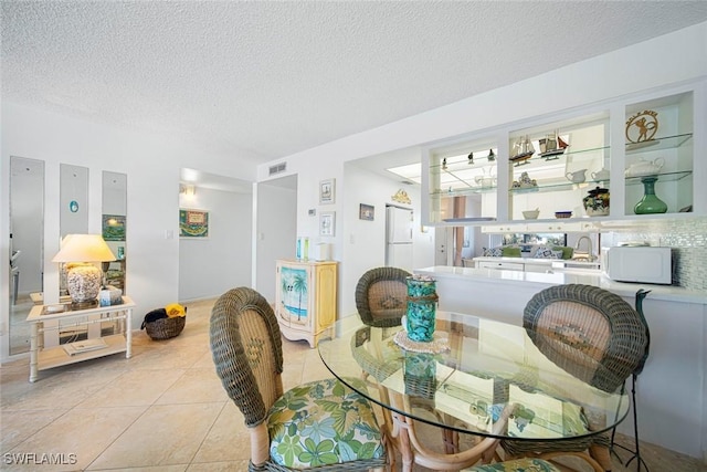 dining room with light tile patterned flooring and a textured ceiling