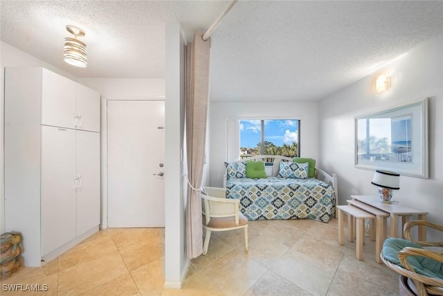 1440 Middle Gulf Dr Unit 2E, Sanibel, FL 33957 - bedroom with a textured ceiling and light tile patterned floors