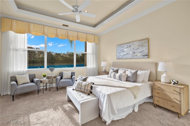 carpeted bedroom with a tray ceiling, ceiling fan, and ornamental molding