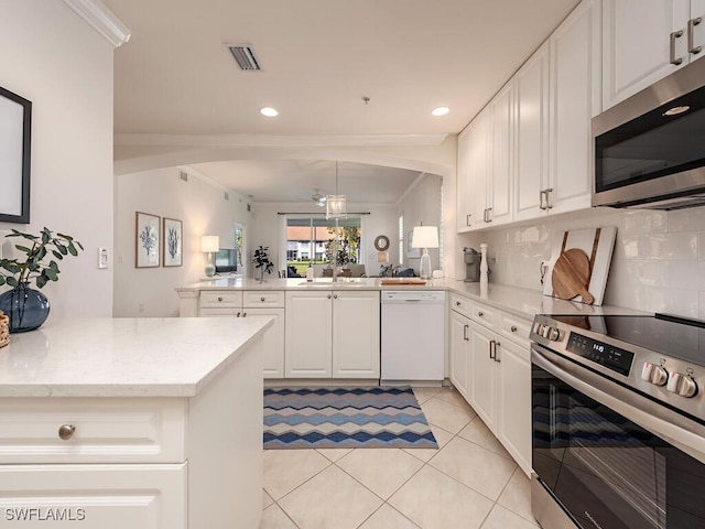 kitchen featuring white cabinetry, kitchen peninsula, ornamental molding, and appliances with stainless steel finishes