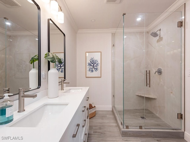 bathroom with vanity, hardwood / wood-style flooring, walk in shower, and crown molding