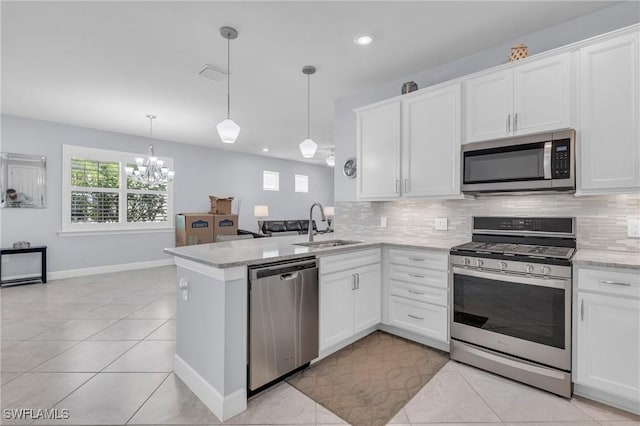 kitchen with pendant lighting, sink, white cabinetry, kitchen peninsula, and stainless steel appliances