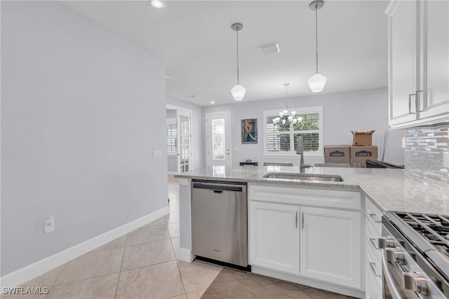 kitchen with appliances with stainless steel finishes, light stone counters, sink, decorative light fixtures, and white cabinetry